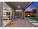 Inviting backyard patio with pavers, a pergola covered seating area, and sliding door to the living area at 2367 Ridgeline Wash St, Las Vegas, NV 89138