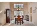 Formal dining room with elegant chandelier, large window and beautiful wood furniture at 2636 Ontario Dr, Las Vegas, NV 89128