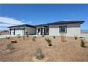 Charming single-story home featuring a three car garage, desert landscaping, and a modern front door at 2900 W Jaybird St, Pahrump, NV 89048