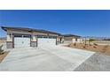 Charming single-story home featuring a three car garage, extended driveway and desert landscaping at 2900 W Jaybird St, Pahrump, NV 89048