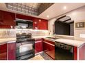 Modern kitchen featuring sleek red cabinets, up-to-date appliances and a practical pass-through window at 4742 Obannon Dr # D, Las Vegas, NV 89102