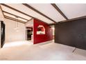 Open-concept living area showcasing bold red accents, beam ceilings and seamless flow into the kitchen at 4742 Obannon Dr # D, Las Vegas, NV 89102