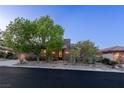 Attractive single-story home featuring mature trees, desert landscaping, and a stone facade at 48 Panorama Crest Ave, Las Vegas, NV 89135