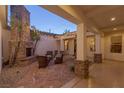 Inviting outdoor patio with a stone fireplace, comfortable seating, and string lights at 48 Panorama Crest Ave, Las Vegas, NV 89135
