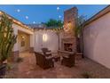 Cozy outdoor patio featuring a stone fireplace, comfortable seating, and ambient string lights at 48 Panorama Crest Ave, Las Vegas, NV 89135
