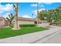 Inviting front yard featuring a well-maintained lawn, mature trees, and charming desert landscaping at 5239 Somerset Dr, Las Vegas, NV 89120