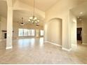 Open-concept living area features neutral tones, decorative lighting, arched doorways, and tile flooring at 5451 Fernwood Ct, Pahrump, NV 89061