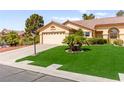 Inviting single-story house with a lush green lawn, mature trees, and a convenient two-car garage at 5612 Beach Mill Way, Las Vegas, NV 89130