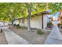 Side view of a tan home with brown trim and trees next to a sidewalk at 5913 Smoke Ranch Rd # A, Las Vegas, NV 89108