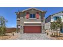 Two story home boasts a red garage door, neutral color scheme, and desert landscaping at 6172 Violet Fls # 42, North Las Vegas, NV 89081