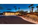 Front exterior showcasing desert landscaping and a circular driveway at twilight at 7521 Prancing Pony Ct, Las Vegas, NV 89131