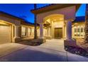 Close up of home's front entrance with decorative pillars, planters, and a tiled roof at 7521 Prancing Pony Ct, Las Vegas, NV 89131
