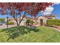 Landscaped front yard with mature shade tree and green grass complements this single Gathering home at 7860 Villa Del Fuego, Las Vegas, NV 89131