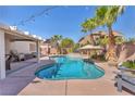 Beautiful backyard pool with palm trees, waterfall feature, covered patio, and desert landscaping at 7860 Villa Del Fuego, Las Vegas, NV 89131