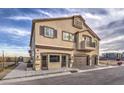 Two-story townhouse includes two-car garage, multiple windows, and inviting front entrance with desert landscaping at 7915 Pandora Sky St # 1, North Las Vegas, NV 89084