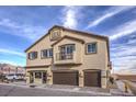 Attractive two-story house boasts a two-car garage and a cozy balcony, set against a blue sky at 7915 Pandora Sky St # 1, North Las Vegas, NV 89084