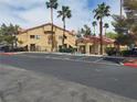 Inviting building exterior showcases well-maintained landscaping, ample parking, and mature palm trees at 900 Heavenly Hills Ct # 219, Las Vegas, NV 89145