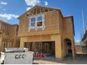 Unfinished two-story home with a garage, wood frame, and a large window at 10032 Indy Rey Ct, Las Vegas, NV 89148