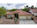 Attractive single-story home with a tile roof, desert landscaping, and a two-car garage at 10201 Los Padres Pl, Las Vegas, NV 89134