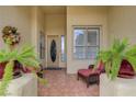 Inviting front porch with tile flooring, comfortable seating, and lush potted plants at 10201 Los Padres Pl, Las Vegas, NV 89134