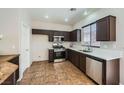 Well-lit kitchen with stainless steel appliances, dark wood cabinetry, and tile floors at 10719 Tottenham Ave, Las Vegas, NV 89135