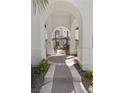 Inviting arched entryway leads to a private courtyard with a wrought iron gate at 11 Caminito Amore, Henderson, NV 89011