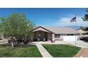 Charming single-story home with a well-kept lawn, a walkway and an American flag at 1540 Labrador St, Pahrump, NV 89048