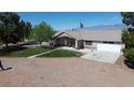 Home featuring an American flag, a front porch, a mature tree and a large driveway at 1540 Labrador St, Pahrump, NV 89048