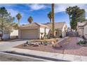 Single-story home with two-car garage, desert landscaping, and neutral exterior paint at 1709 Autumn Rust Dr, Las Vegas, NV 89119