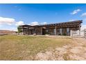 Expansive backyard featuring a pergola-covered patio, lawn, and white fencing at 1988 N Moapa Valley Blvd, Logandale, NV 89021