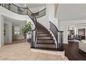 Grand foyer with a curved staircase, elegant tile flooring, and views into the dining and living areas at 2445 Ping Dr, Henderson, NV 89074