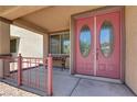 Close-up of elegant double front door with oval glass inserts and a covered porch with cozy seating at 4216 Thunder Twice St, Las Vegas, NV 89129