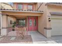 Charming front porch with seating area, double doors, desert landscaping, and decorative light fixture at 4216 Thunder Twice St, Las Vegas, NV 89129