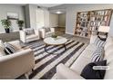 Bright, staged living room featuring a striped rug, comfortable seating, and a stylish bookcase at 5286 River Glen Dr # 421, Las Vegas, NV 89103