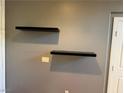 Stylish gray wall with minimalist black floating shelves, adding modern flair to the room at 5425 Whisper Bluff St, North Las Vegas, NV 89031