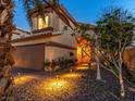 Inviting home exterior showcasing meticulous landscaping, pathway lighting, and warm, welcoming glow at 5779 Baffy Cir, Las Vegas, NV 89142