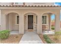 Inviting front porch with an arched entryway, dark brown front door, and a cozy seating area at 8507 Insignia Ave # 102, Las Vegas, NV 89178