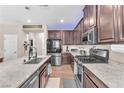 Gourmet kitchen with granite countertops, stainless steel appliances, and dark wood cabinetry at 8507 Insignia Ave # 102, Las Vegas, NV 89178