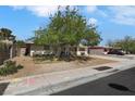 A single-story home with mature trees and desert landscaping enhancing its curb appeal at 1041 E Saint Louis Ave, Las Vegas, NV 89104