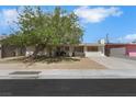 Quaint single-story house with mature trees and desert landscaping enhancing curb appeal at 1041 E Saint Louis Ave, Las Vegas, NV 89104