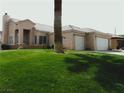 Single-story home with a two car garage and lush green lawn in the front yard at 1160 Golf Club, Laughlin, NV 89029