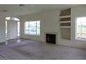 Open living room with bright windows and a cozy fireplace at 1160 Golf Club, Laughlin, NV 89029