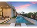 Tranquil backyard oasis with a modern pool, lounge chairs, and lush landscaping creating a private retreat at 144 Tre Pietre St, Henderson, NV 89011