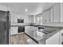 The modernized kitchen features granite countertops, sleek black appliances, and all-white cabinetry at 2204 Monterey Ave, Las Vegas, NV 89104