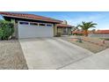 A wide driveway leading to an attached two-car garage, surrounded by desert landscaping and a red tile roof at 291 Lido Dr, Henderson, NV 89015
