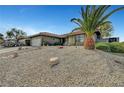 Single-story home with desert landscaping, rock mulch, and a mature palm tree in the front yard at 291 Lido Dr, Henderson, NV 89015