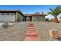 View of the front of the home, showcasing a red tile roof, a brick walkway, and desert landscaping at 291 Lido Dr, Henderson, NV 89015