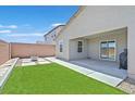 A serene backyard retreat with artificial turf, pavers, and a cozy covered patio for outdoor living at 442 Bridal Veil Falls St, Indian Springs, NV 89018