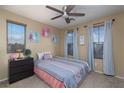 Cozy bedroom with a ceiling fan, carpeted floors and bright natural lighting at 4804 Portola Vista Ave, Las Vegas, NV 89139
