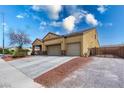 Exterior view showcasing a two-car garage and gated gravel driveway at 6636 Brent Scott St, North Las Vegas, NV 89086